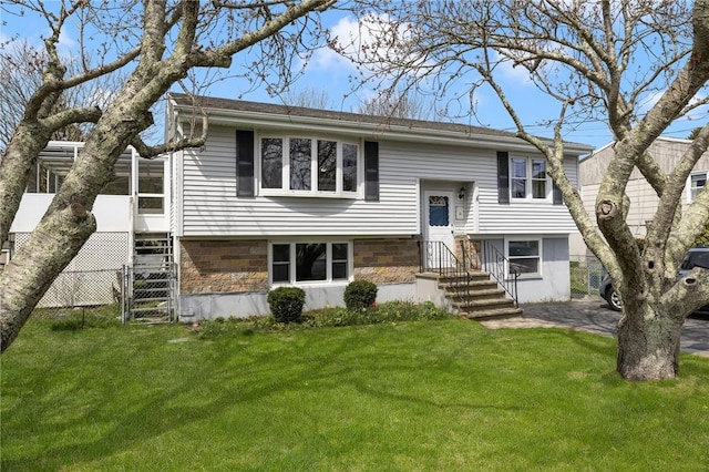 split foyer home featuring a front yard and a sunroom