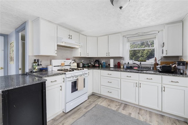 kitchen with a sink, under cabinet range hood, light wood-style floors, white range with gas stovetop, and a textured ceiling