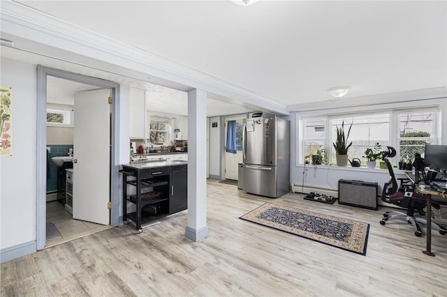 office space featuring baseboards, light wood-style flooring, and a baseboard radiator