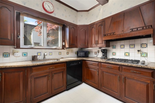 kitchen featuring wallpapered walls, black appliances, a sink, light stone counters, and light floors