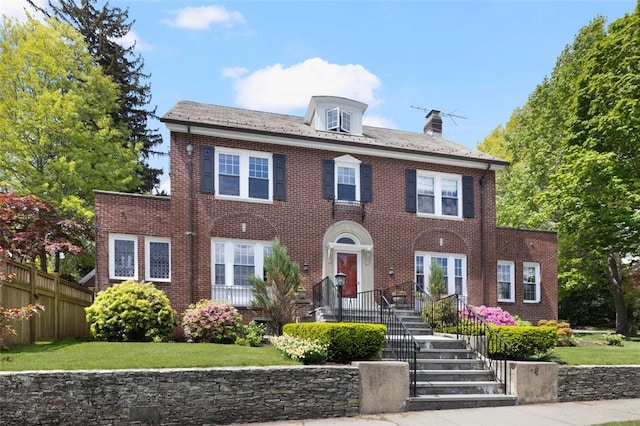 view of front of home with brick siding and a chimney