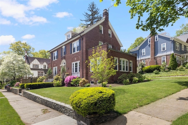 view of property exterior with brick siding, a lawn, a residential view, and a chimney