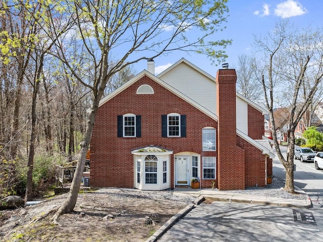 view of front of house featuring a chimney and brick siding