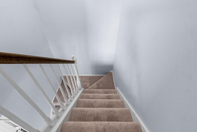 stairway with baseboards and carpet