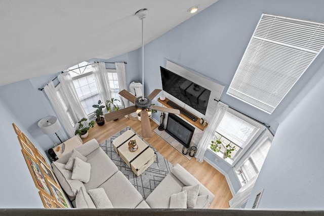 living area with vaulted ceiling, wood finished floors, and a fireplace