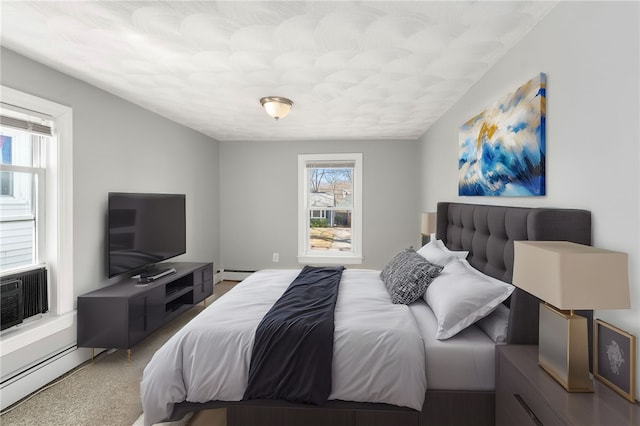 carpeted bedroom featuring a baseboard heating unit