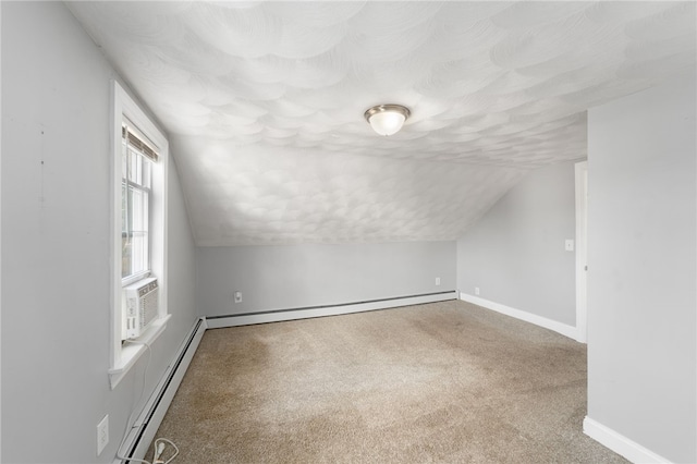 additional living space with baseboard heating, baseboards, carpet floors, and vaulted ceiling