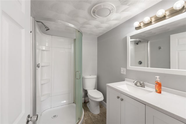 bathroom featuring toilet, a shower stall, and vanity