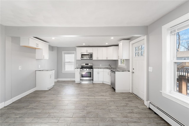 kitchen with recessed lighting, baseboard heating, stainless steel appliances, and light wood-style floors