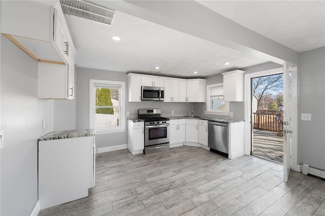 kitchen featuring visible vents, stainless steel appliances, light wood-type flooring, and baseboards