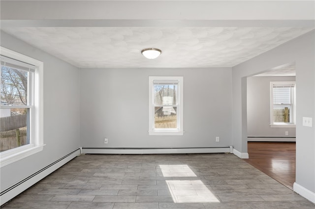 unfurnished room with a wealth of natural light, baseboard heating, and a baseboard radiator