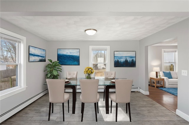 dining area with a healthy amount of sunlight, baseboards, and a baseboard radiator