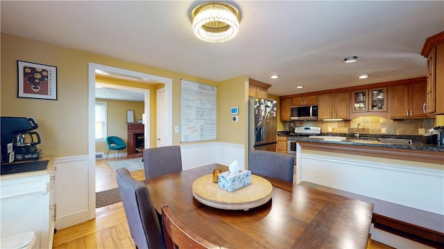 dining area featuring recessed lighting, light wood-style flooring, and a fireplace