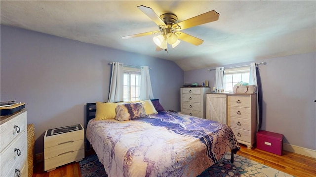 bedroom featuring a ceiling fan, baseboards, lofted ceiling, and dark wood-type flooring