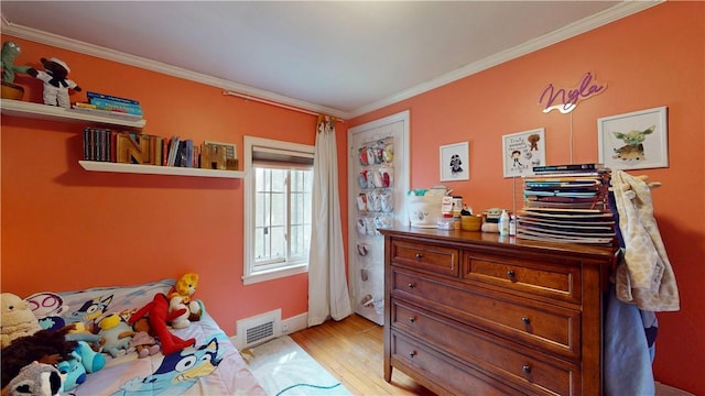 bedroom featuring crown molding, baseboards, visible vents, and light wood-type flooring