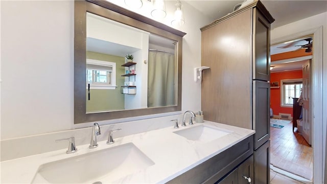 full bathroom with double vanity, a sink, and ceiling fan