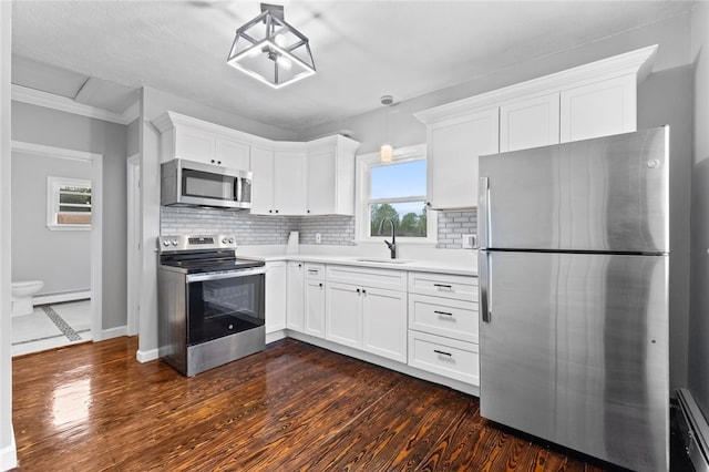 kitchen featuring decorative backsplash, a baseboard heating unit, appliances with stainless steel finishes, a sink, and white cabinetry