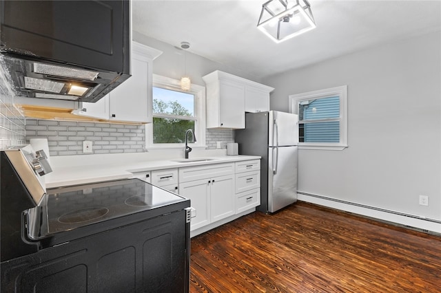 kitchen with freestanding refrigerator, black electric range oven, tasteful backsplash, and a sink