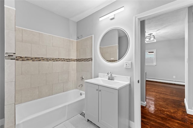 bathroom featuring a baseboard radiator, wood finished floors, vanity, and  shower combination