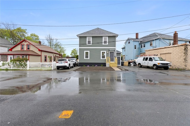 view of front of property with fence, uncovered parking, and a residential view