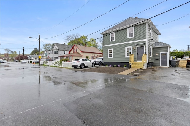american foursquare style home with uncovered parking and a shingled roof