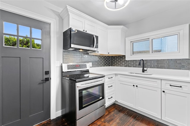 kitchen with backsplash, a sink, appliances with stainless steel finishes, and dark wood-style flooring