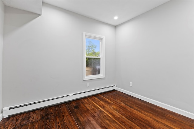 empty room with recessed lighting, baseboard heating, wood finished floors, and baseboards