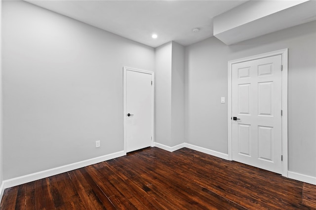 unfurnished room with dark wood-style flooring, recessed lighting, and baseboards