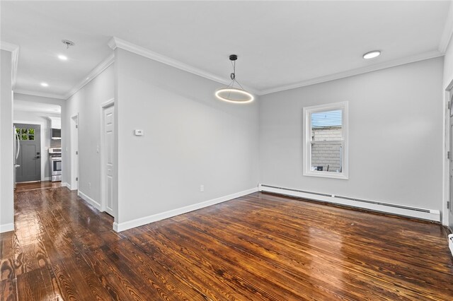 spare room featuring a baseboard heating unit, ornamental molding, hardwood / wood-style flooring, and plenty of natural light