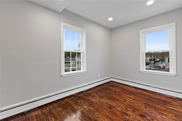 empty room with recessed lighting, wood finished floors, and a baseboard radiator