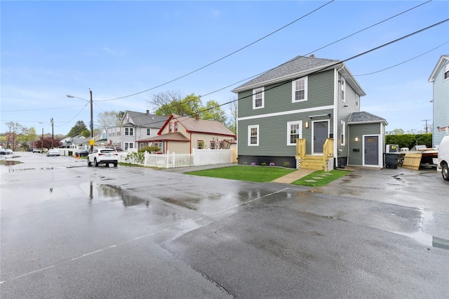 view of front of home with fence and a residential view