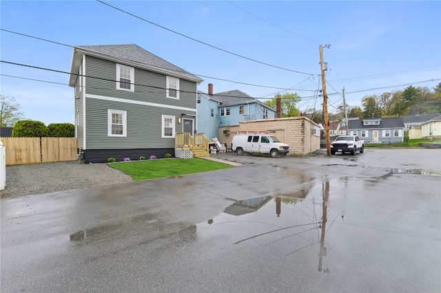 view of front of property with uncovered parking and fence