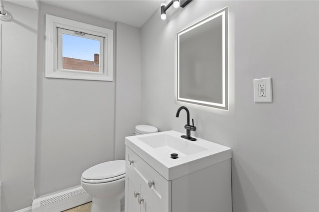 half bath with vanity, toilet, and baseboard heating