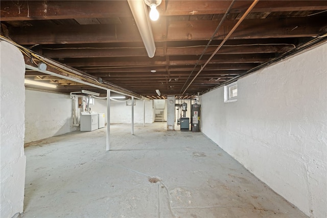 below grade area featuring gas water heater, separate washer and dryer, and stairway