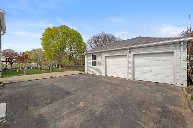 detached garage featuring fence