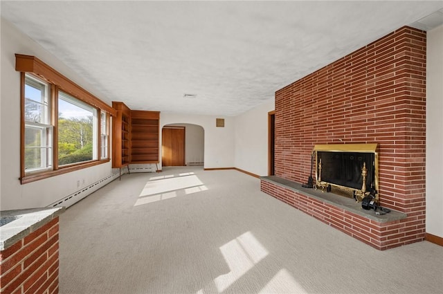 21 Top St, Westerly, RI 02891 - unfurnished living room with baseboards, arched walkways, a brick fireplace, and carpet flooring