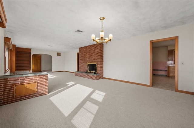 21 Top St, Westerly, RI 02891 - unfurnished living room featuring visible vents, a brick fireplace, baseboards, arched walkways, and a notable chandelier