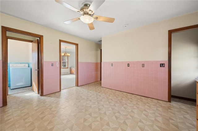 21 Top St, Westerly, RI 02891 - spare room with wainscoting, ceiling fan with notable chandelier, washer / clothes dryer, tile walls, and light floors