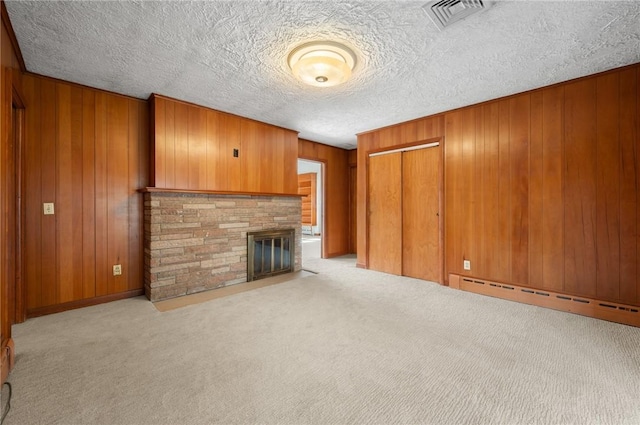 21 Top St, Westerly, RI 02891 - unfurnished living room with visible vents, carpet floors, a stone fireplace, wooden walls, and baseboard heating