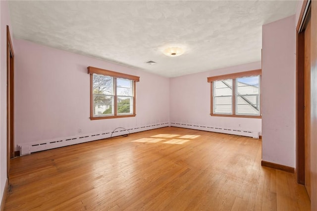 21 Top St, Westerly, RI 02891 - spare room featuring baseboard heating, a textured ceiling, baseboards, light wood-type flooring, and visible vents