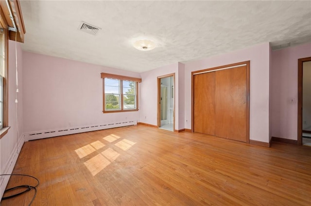 21 Top St, Westerly, RI 02891 - unfurnished bedroom with visible vents, a baseboard heating unit, a closet, and light wood-type flooring