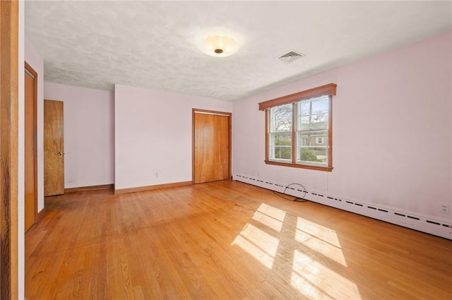 21 Top St, Westerly, RI 02891 - unfurnished bedroom featuring visible vents, a closet, light wood-style floors, baseboards, and baseboard heating