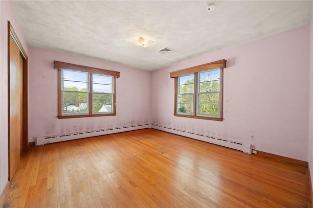 21 Top St, Westerly, RI 02891 - spare room with light wood-style floors, plenty of natural light, and a baseboard heating unit