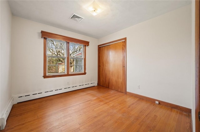21 Top St, Westerly, RI 02891 - unfurnished bedroom featuring visible vents, a closet, baseboards, a baseboard heating unit, and light wood finished floors