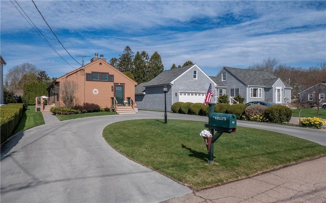 view of front facade featuring a front yard and curved driveway