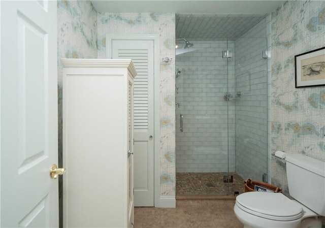 full bath with tile patterned floors, a shower stall, and toilet