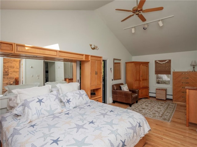 bedroom featuring track lighting, light wood-style flooring, high vaulted ceiling, and a baseboard radiator