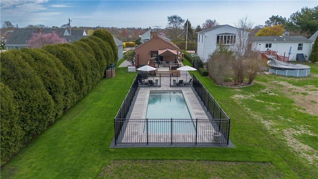 view of pool featuring a fenced in pool, a lawn, a residential view, and a fenced backyard