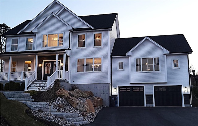 view of front of property featuring a garage, covered porch, and driveway