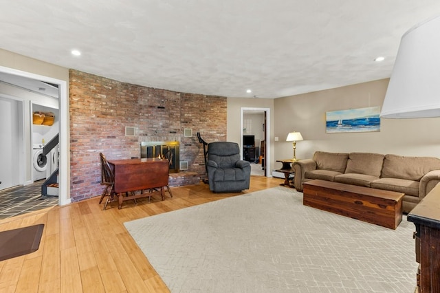 living room featuring recessed lighting, washer / dryer, and hardwood / wood-style floors